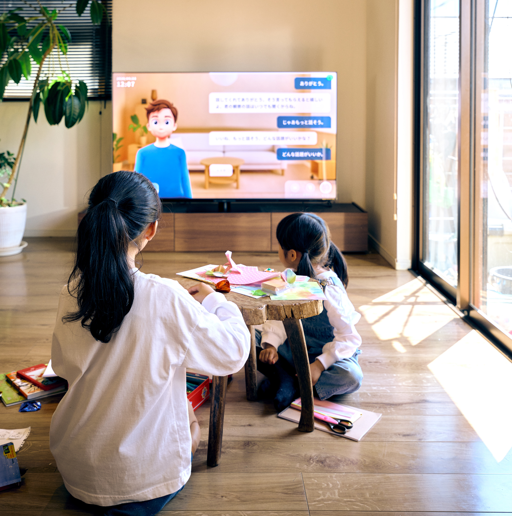 写真:リビングで子供と一緒にAQUOS AIを楽しむ家族