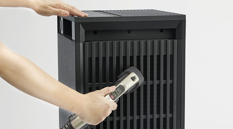 空気清浄機のフィルターを掃除機のアタッチメントで手軽に掃除する様子。